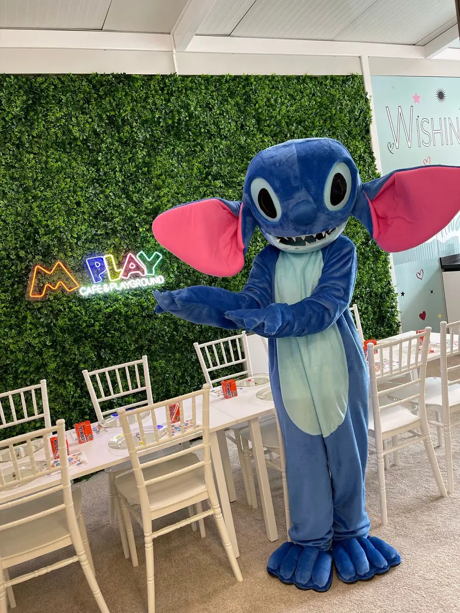 A costumed mascot greeting guests at the birthday table