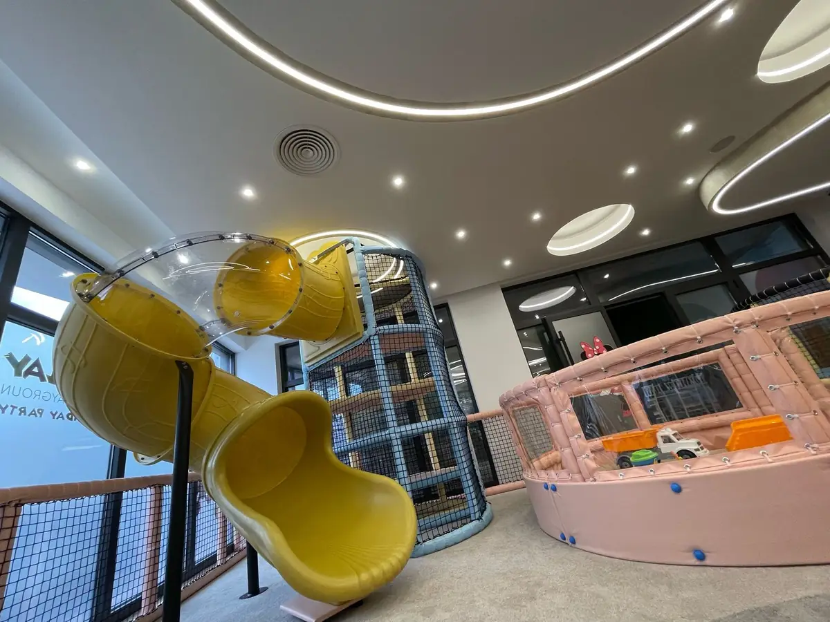 The multi-level play frame with netting, tunnels and a yellow slide
