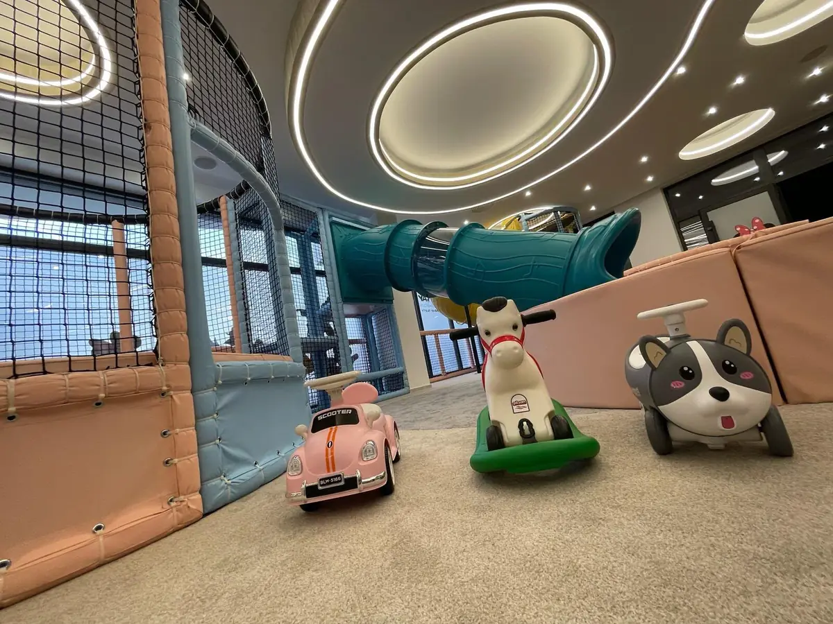 Ride-on cars and toys in front of the slide