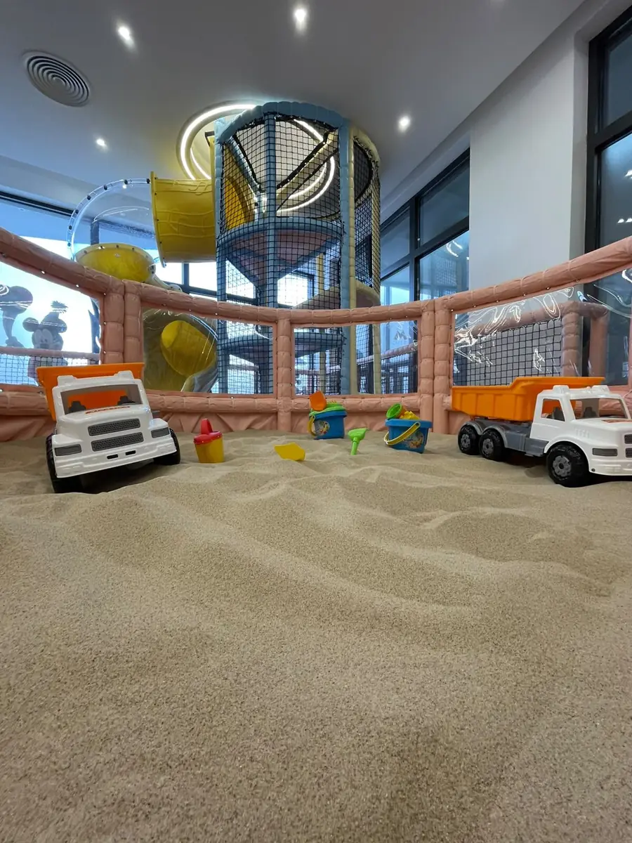 The indoor sand area, with toy trucks and spades