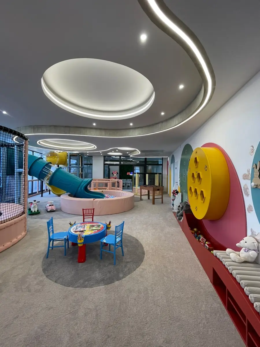 The toddler corner with a small table, chairs and activity panels on the wall